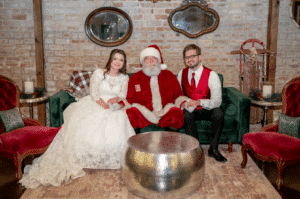 Bride and groom celebrating a December wedding with Santa Claus at Butler's Courtyard, a charming wedding venue in League City near Houston, Texas, perfect for festive and magical holiday-themed weddings.