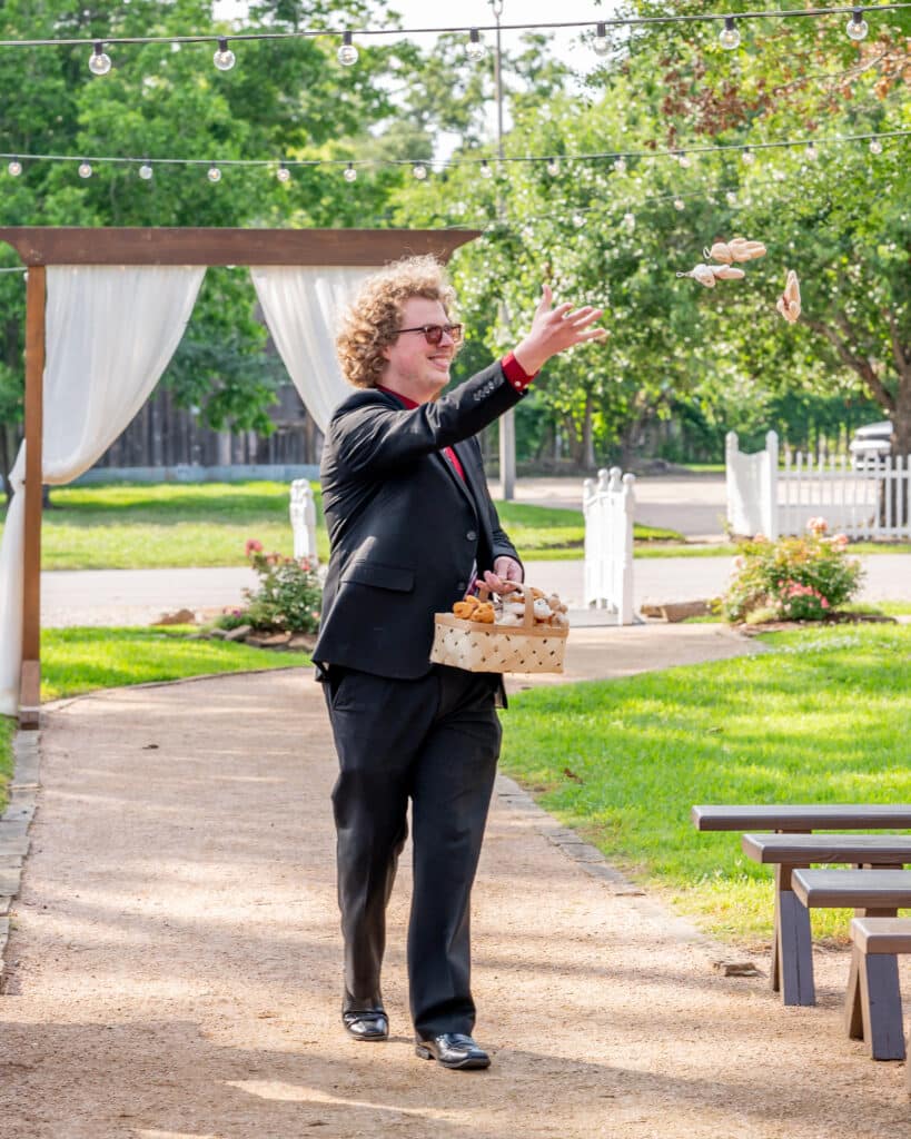 Flower Man smiles as he tosses tiny teddy bears to guests while walking down the aisle ahead of the Bride. 
