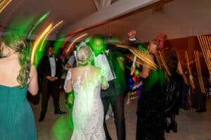 Bride and groom dancing at their fun wedding reception in the Pavilion at Butler's Courtyard. Glow wands create a unique lighting effect on the reception dance floor, highlighting this unique wedding venue experience. Keywords include unique wedding venue, pavilion wedding, Butler's Courtyard, fun wedding reception, wedding dance floor, reception dance floor, glow wands, and unique lighting.