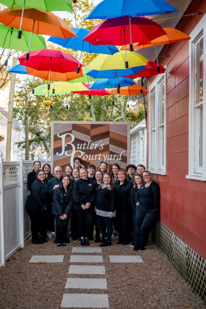 The full service team of Butler's Courtyard works hard to make sure you have a stress free wedding day Houston. Here they smile under the Umbrella Alley