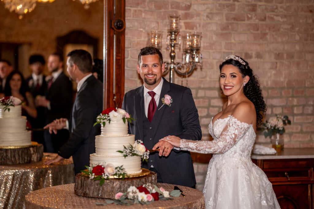 Smiling Bride and Groom cut their wedding cake at Butler's Courtyard Houston Texas wedding venue