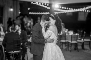 Black and White wedding photo of Bride and Groom smiling during their romantic first dance