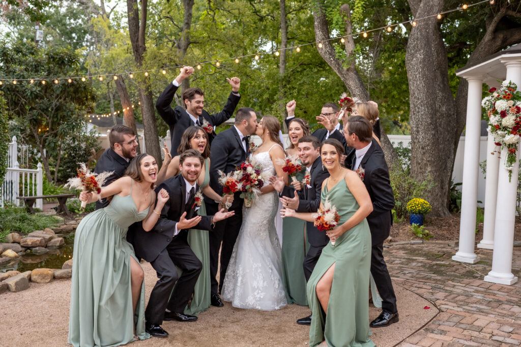 Fall wedding in Houston. Wedding party smiling and laughing together during a joyful fall wedding at Butler's Courtyard, enjoying perfect weather and surrounded by seasonal charm with vibrant autumn-inspired décor at Butler's Courtyard Houston wedding venue 