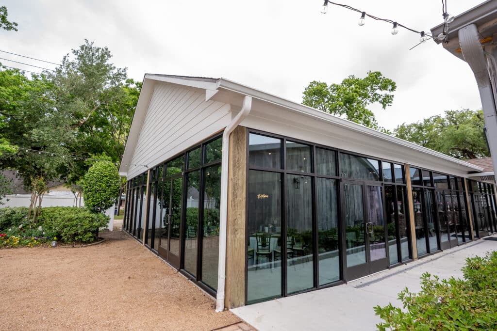 A view outside looking in to the Ballroom at Butler's Courtyard, a modern reception space, from the ceremony location. 