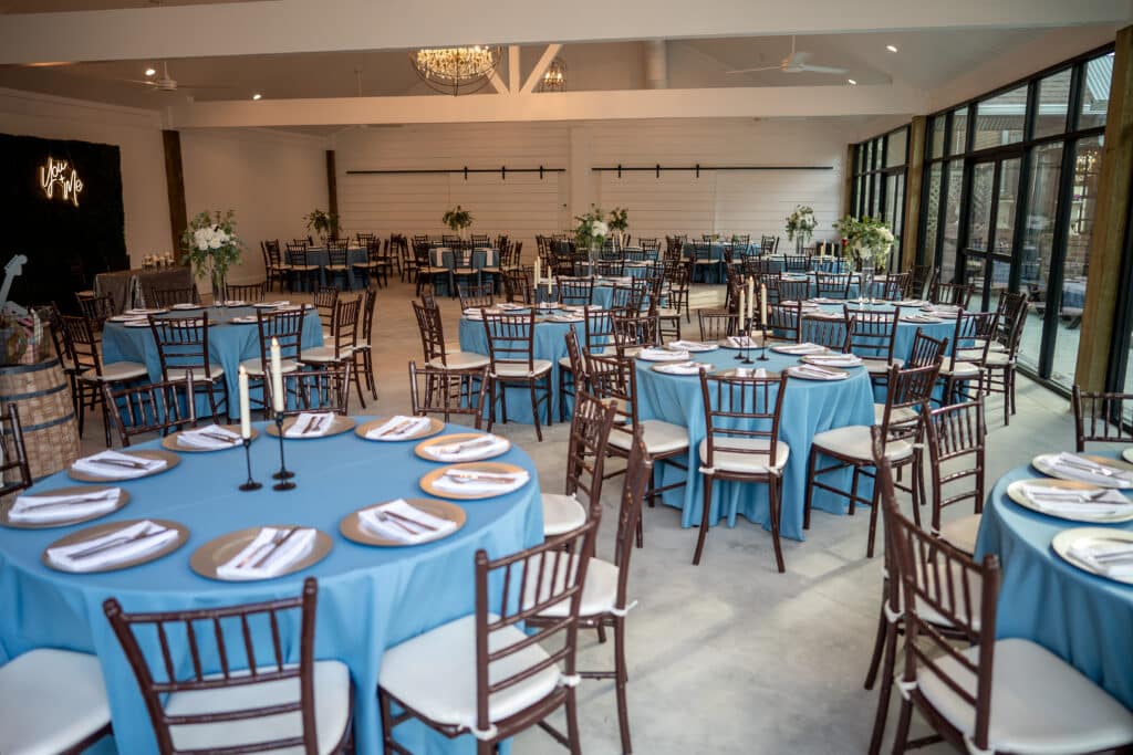 Ballroom at Butler's Courtyard, a modern reception space, set with beautiful blue linens and custom table settings making it the perfect wedding venue in Houston Texas