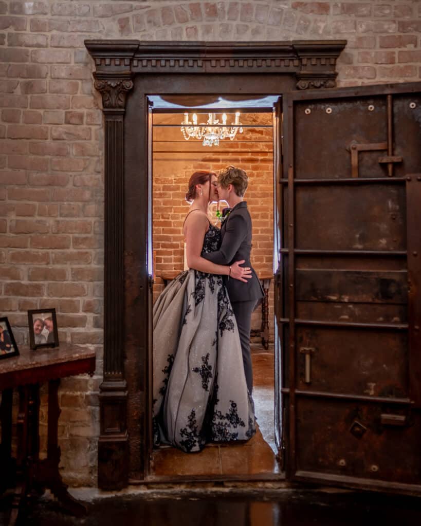 Two Brides kiss in the historic vault at Butler's Courtyard, an LGBTQ Friendly Historic Wedding Venue in Houston