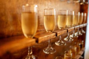 Champagne Wall at a Houston Wedding Venue, Bubbly golden champagne in glass flutes on a wooden wall